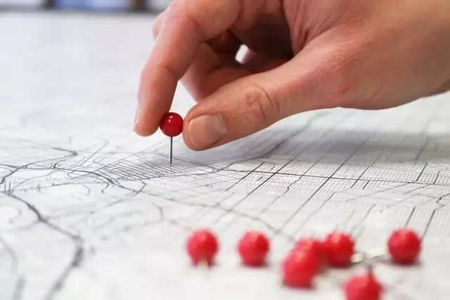 person pinning a map in a geographical target market